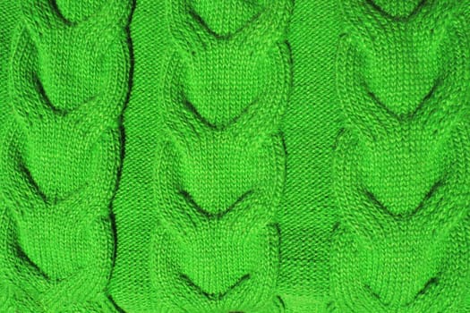 Pigtail knit. Pattern of knitted fabric. Green yarn. Front and back loops. Knitted pattern close up. Knitting as a hobby. Women's needlework. Knit for warm sweaters