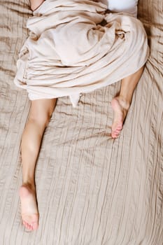 Unrecognizable woman sleeps lying on her stomach with one leg tucked under her