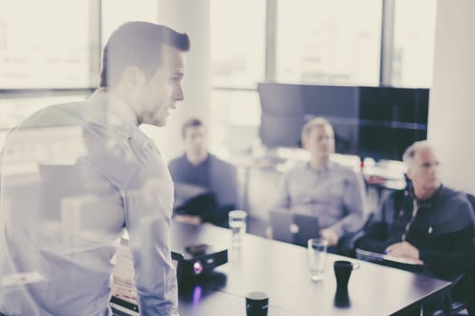 Business man making a presentation at office. Business executive delivering a presentation to his colleagues during meeting or in-house business training, explaining business plans to his employees.