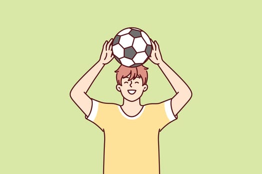 Teenage boy raises soccer ball over head dreams of becoming professional football player and playing in Major League. Young guy in yellow T-shirt stands on green lawn. Flat vector illustration