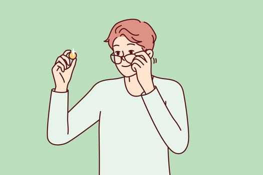 Positive man examines gold coin or piece of jewelry and lowers glasses from eyes to view rare exhibit. Guy is fond of numismatics and collecting coins from precious metals. Flat vector design