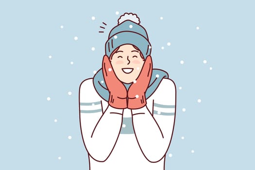 Happy man in sweater and mittens smiling enjoy cold weather and rejoice december holidays. Positive young guy in winter hat and scarf stands outdoors among falling snowflakes. Flat vector design