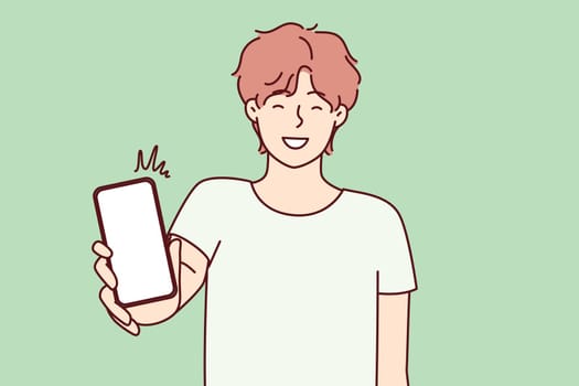 Happy man showing smartphone screen and smiling to recommend cool applications. Positive college age guy holding mobile phone with blank display boasts website. Flat vector illustration