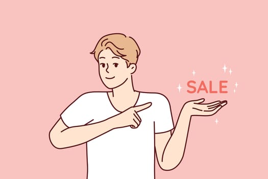 Positive man pointing finger at inscription sale, inviting for profitable shopping in supermarket or online store. Optimistic guy dressed in casual t-shirt for marketing campaign. Flat vector design