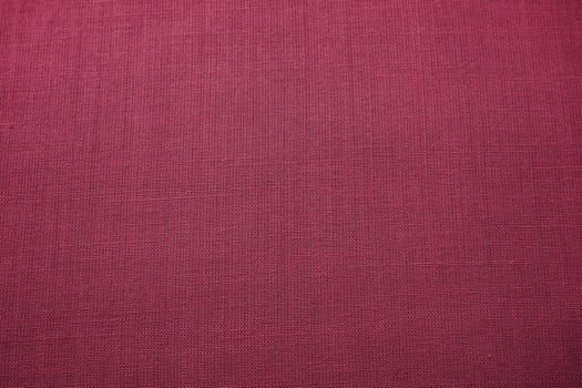 red, burgundy background fabric texture. A piece of woolen cloth is neatly laid out on the surface. Weave and textile texture. Dress fabric or for kitchen needs, tablecloth or curtains, close-up Dash.