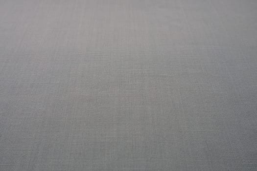 gray background fabric texture. A piece of woolen cloth is neatly laid out on the surface. Weave and textile texture. Dress fabric or for kitchen needs, tablecloth or curtains, close-up. Dash.