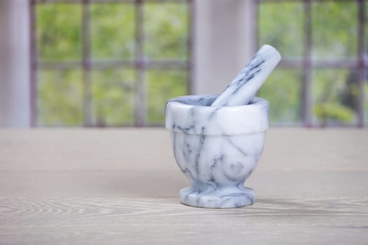 A mortar and pestle on wooden kitchen surface