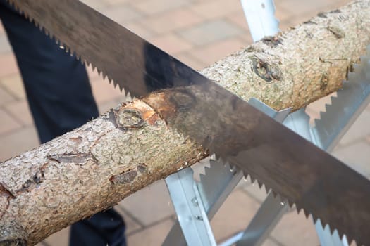 Details of a sawhorse with log and saw at a wedding.