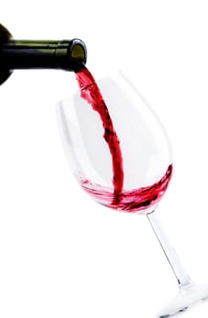 Red wine pouring in wine glass isolated over white background. Red wine splashing in wineglass.
