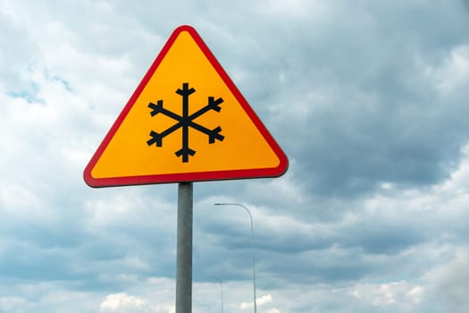 Yellow road sign warning of road frosting, snowflake