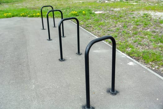 Empty small bicycle parking in urban space and green grass.