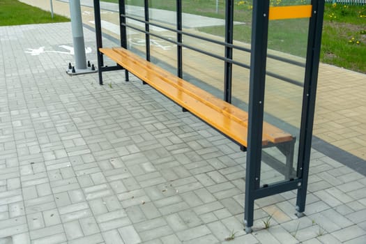 New glass shelter bus stop with wooden bench
