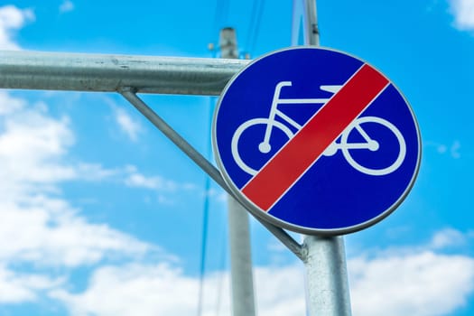 Round blue sign, no cycling and sky, close up