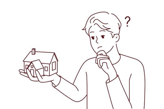 Young man holding house thinking of mortgage or loan. Confused male with home maquette frustrated with housing rent or purchase. Real estate agent. Vector illustration.