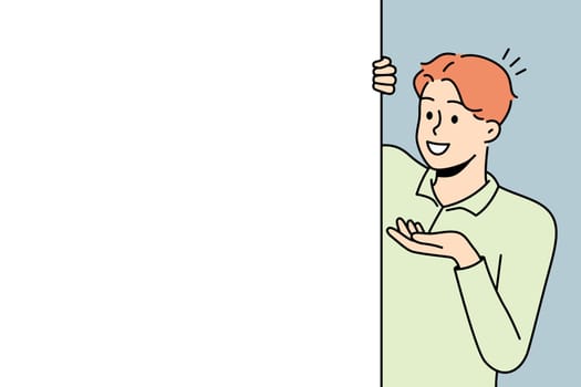 Smiling man look behind mockup poster
