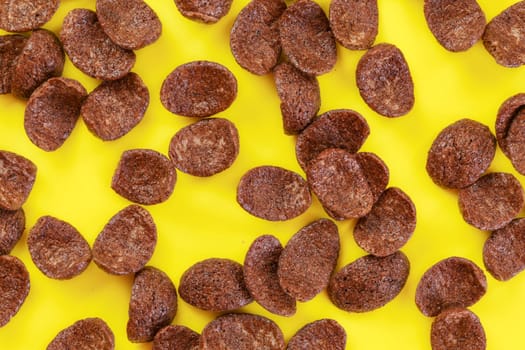 Tabletop photo, chocolate corn flakes on yellow board.
