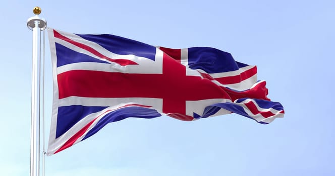 United Kingdom flag waving in the wind on a clear day. Union Jack. Blue field with red, white crosses of patron saints. Rippled fabric. Realistic 3d illustration