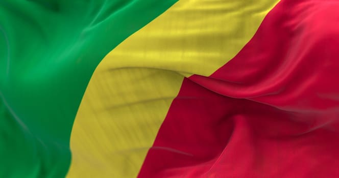 Close-up of the Republic of the Congo national flag. Diagonal yellow band, green and red triangles on hoist corner. Rippled fabric. Textured background. Selective focus. Realistic 3d illustration