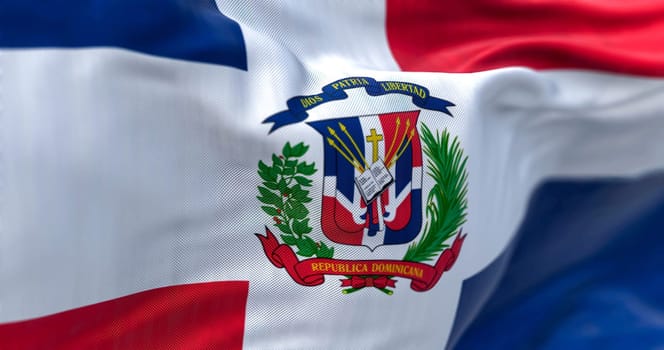 Close-up of the Dominican Republic flag. Red and blue flag with white cross, coat of arms in center. Rippled fabric. Textured background. Selective focus on the coat of arms. Realistic 3d illustration