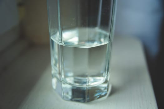 Half glass of water standing on the kitchen counter
