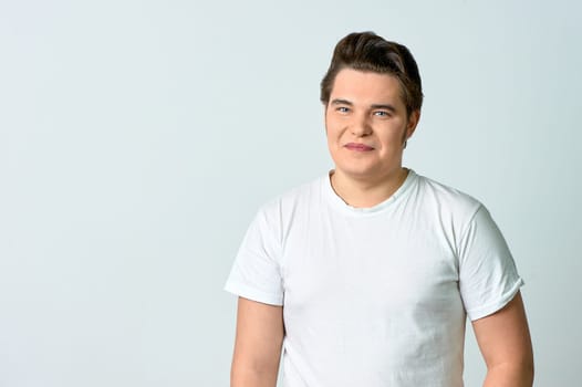 A man on a light background smiles. Emotions. High quality photo