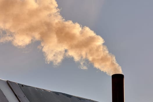 smoke is coming from the chimney of the bourgeoisie. the stove is being heated. High quality photo