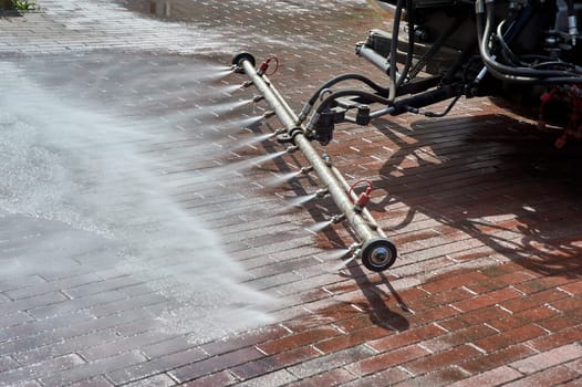 A special machine washes city paths and roads with water. High quality photo