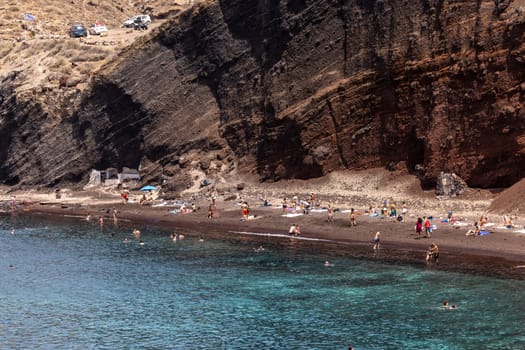 Santorini, Greece - July 01, 2021: The famous Red beach on the south coast of Santorini island, Cyclades, Aegean Sea.