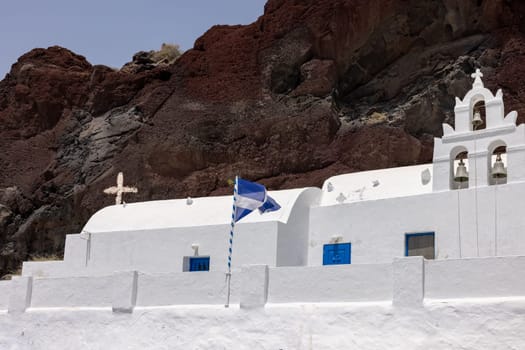 Greek church built into the mountain located near the famous Red Beach of Akrotiri. Santorini Island, Greece
