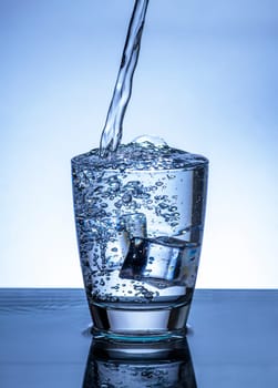 The image of pouring drinking water, into a glass, that makes one feel refreshed on blurred white background, Splashing water, Sparkling water