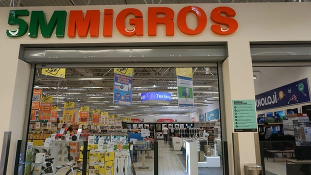 Chorlu, Turkey - September 23, 2022: Migros supermarket logo hanging on a building in Chorlu. Migros company is the biggest retail and wholesale company of Switzerland