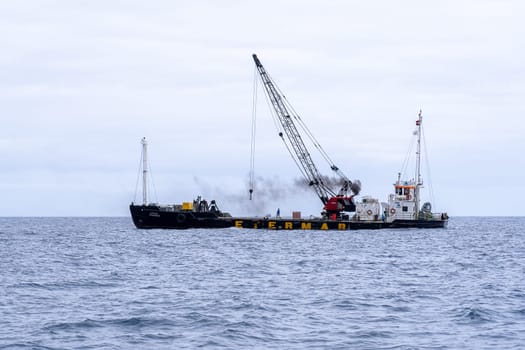 Madeira / Portugal - July 15, 2021. The industrial ship with workers moored at Madeira coast.