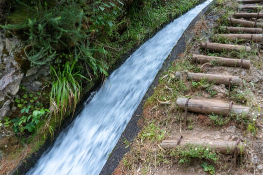 The path by beautiful irrigation canal named levadas in Madeira island, Portugal.