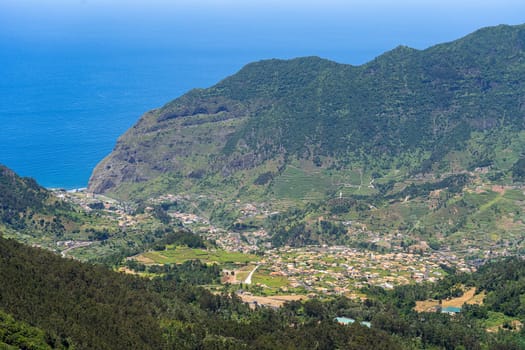 Aerial view on small city Sao Vicente - Chapel on the hill, huge mountains on background. Madeira island, Portugal.