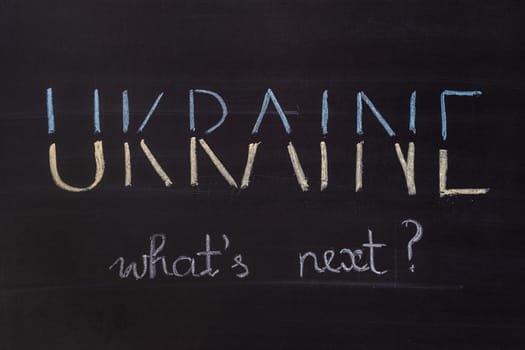 Word "Ukraine, What's next"" writed on blackboard with chalk"
