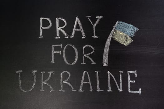 Words "Pray for Ukraine"" writed on blackboard with chalk"