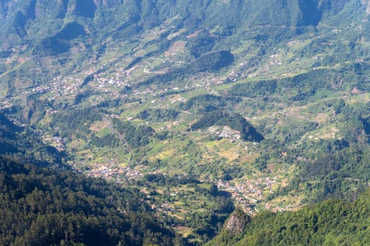Aerial view on small city, huge mountains on background. Madeira island, Portugal.