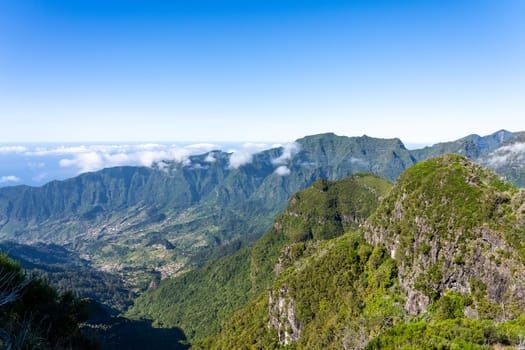 Aerial view on small city, huge mountains on background. Madeira island, Portugal.