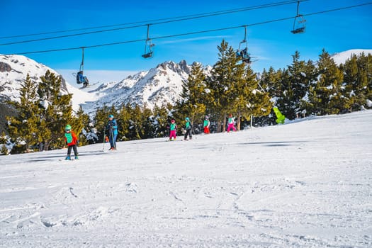 El Tarter, Andorra, Jan 2020 Ski trainer or instructor teaching a group of young kids how to ski. Winter holidays in Pyrenees Mountains, Grandvalira