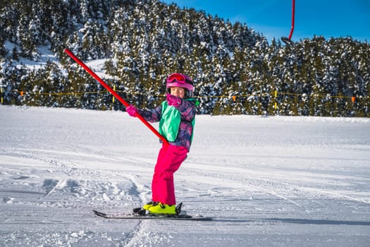 Young skier, a child, having fun when riding up on a ski drag lift. Winter holidays in El Tarter, Andorra, Pyrenees Mountains, Grandvalira