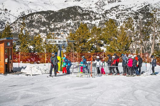 El Tarter, Andorra, Jan 2020 Ski instructor teaching a group of young kids how to ski and get on ski drag lift. Winter holidays in Pyrenees Mountains