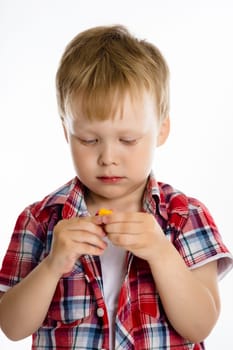 Little boy standing playing with toy. studio