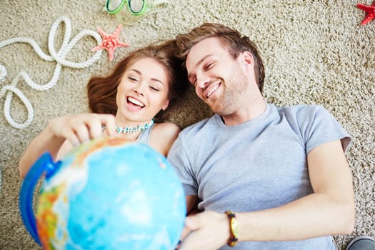 Young couple with globe dreaming of summer vacations