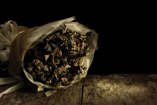 Still life with flower on black background and old wooden table, Dried flowers preserved as a memorial and feelings of the past in the past.