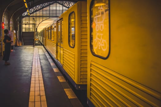 Berlin, Germany, June 2022: Waiting for the yellow train at an U-Bahn metro station in Berlin
