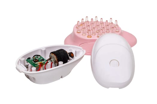 An old opened battery operated scalp massage brush, which has rusted due to moisture penetration inside and has thus been destroyed. Beauty and health concept.