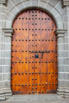 Old massive large wooden door in a stone wall of a church.