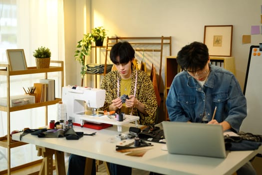 Young fashion designers collaborating on new project in a studio.