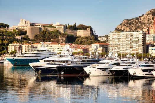 Monte Carlo, Monaco - August 2022: Port Hercule with luxury yachts,  boats, and scenery skyline