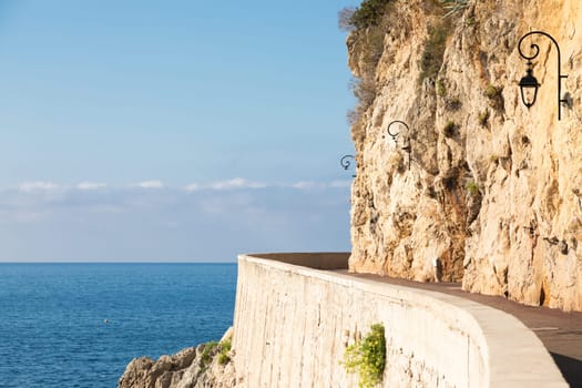Promenade in front of the sea. Blue sky on scenery seascape. Concept of travel, adventure, freedom